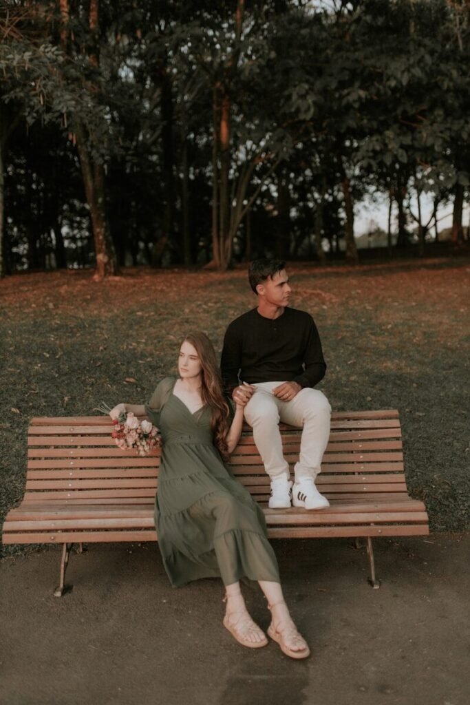 A man and woman sitting on a bench in a park