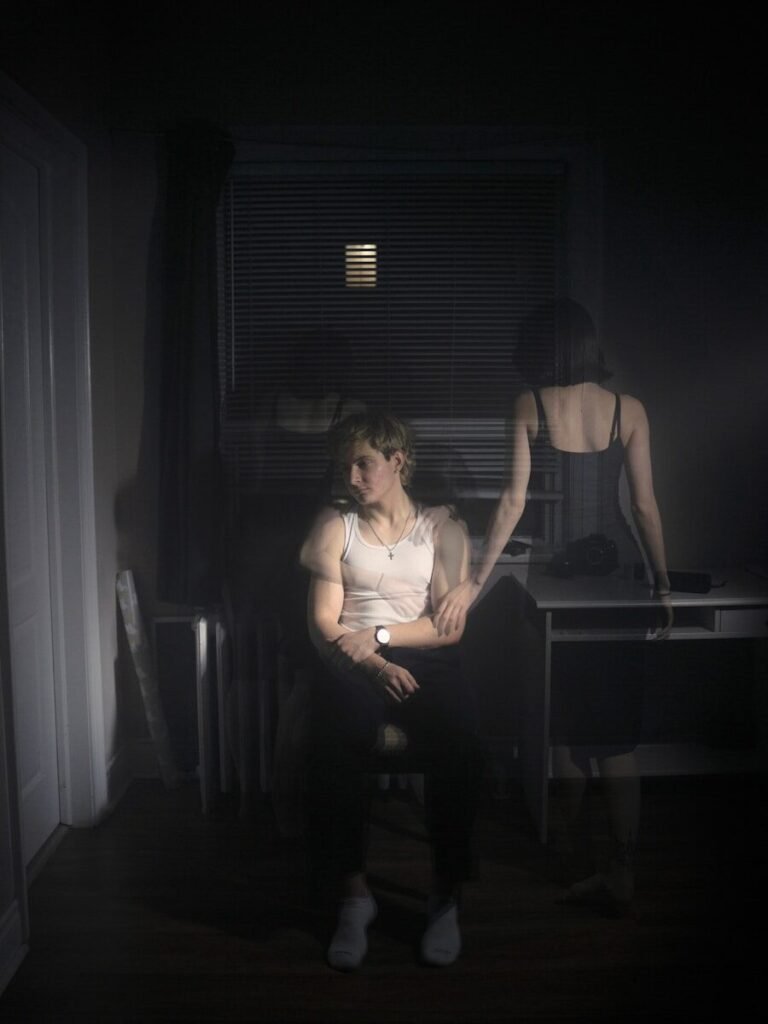 A woman sitting on a chair in a dark room