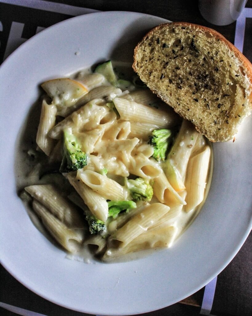 A white plate topped with pasta and broccoli