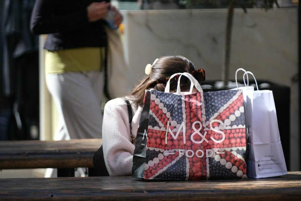 Woman with m&s food shopping bags on table