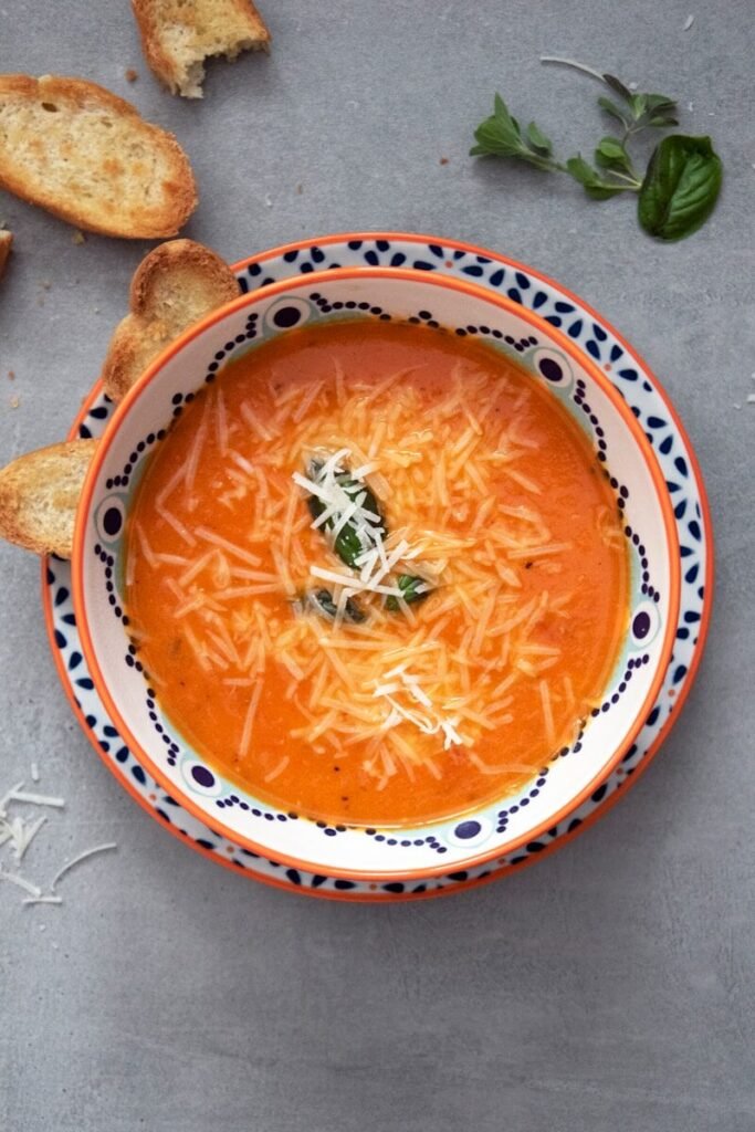 orange soup on white and blue ceramic bowl